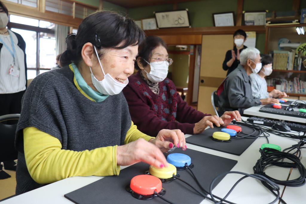 高齢者グループがUDe-スポーツのカラーボタンを操作している様子